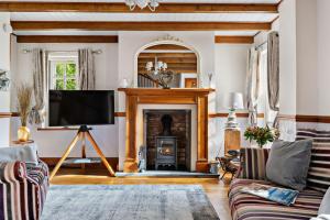 een woonkamer met een open haard en een flatscreen-tv bij Beryas Cottage in Newlyn