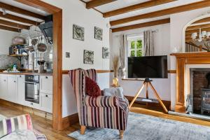 een woonkamer met een tv en een stoel bij Beryas Cottage in Newlyn