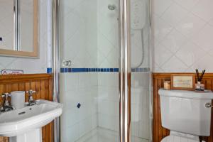 een badkamer met een douche, een toilet en een wastafel bij Beryas Cottage in Newlyn +14 foto's