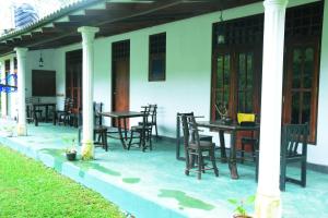 a patio with tables and chairs on a house at Ranpokuna Bungalow with 3 Bed Rooms in Kiriella