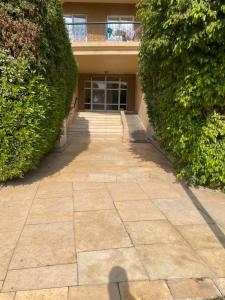 einen Gehweg vor einem Gebäude mit Büschen in der Unterkunft El Rehab city in New cairo