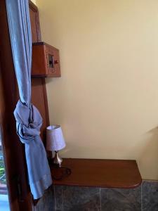 ein Zimmer mit einem Bett, einem blauen Vorhang und einer Lampe in der Unterkunft Noby Gili Cottages in Gili Meno