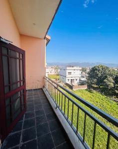 a balcony with a red door and a view at The Nest spacious and homely flat in Haldwani in Haldwāni