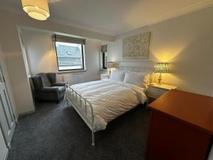 une chambre avec un lit, un bureau et une chaise dans l'établissement Seabird Cottage, Harrapool Isle of Skye, à Broadford