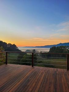 a wooden deck with the sunset in the background at Oliveira mountain House in Tijucas