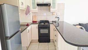 a small kitchen with a stove and a refrigerator at Villa Moya 46 in Margate