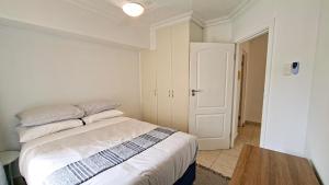 a bedroom with a bed with white sheets and a table at Villa Moya 46 in Margate