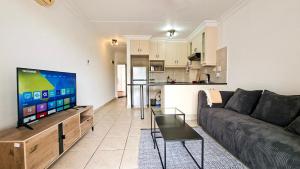 a living room with a couch and a tv and a kitchen at Villa Moya 46 in Margate