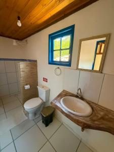 a bathroom with a sink and a toilet and a window at Pousada chalés São Geraldo in Lima Duarte +30 photos