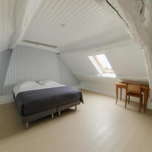 - une chambre avec un lit et une fenêtre mansardée dans l'établissement Superbe Duplex de 2 Chambres au cœur de Gouvieux, à Gouvieux