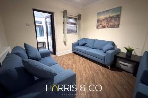 ein Wohnzimmer mit einem blauen Sofa und Sofas in der Unterkunft Sandringham & Spa Villa in Thornton