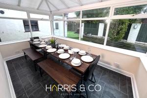 una sala da pranzo con un lungo tavolo e sedie di Sandringham & Spa Villa a Thornton