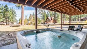 a jacuzzi tub in a porch with a view at Walk to Lake 7BDR HotTub Movie Theater GameRoom Dawn and Dusk by AvantStay in Big Bear Lake
