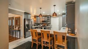 a kitchen with a large island with wooden chairs at Walk to Lake 7BDR HotTub Movie Theater GameRoom Dawn and Dusk by AvantStay in Big Bear Lake