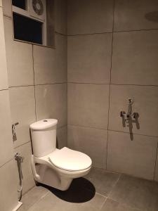 Un baño con un inodoro blanco en una habitación. en Kochipods, en Ernakulam