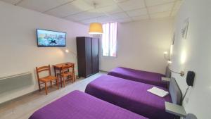 a living room with a purple couch and a table at Hôtel du Roc in Castellane