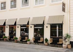 a row of tables and chairs in front of a building at Hotel Petra in Copenhagen