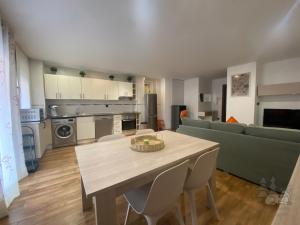 eine Küche und ein Wohnzimmer mit einem Tisch und einer Couch in der Unterkunft EL DESCANSO DE PINARES - VuT en Huerta de Rey in Huerta del Rey