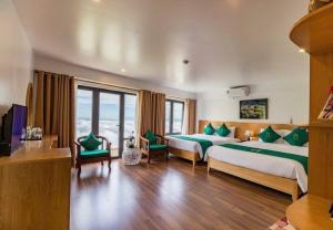 ein Hotelzimmer mit zwei Betten und einem großen Fenster in der Unterkunft Sapa Emerald Hotel in Sa Pa