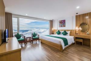 ein Hotelzimmer mit einem Bett und einem großen Fenster in der Unterkunft Sapa Emerald Hotel in Sa Pa