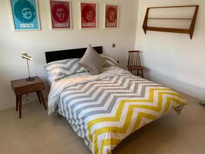 a bedroom with a bed with a yellow and white comforter at Eight Water's Edge in Tenby