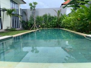 een zwembad voor een huis bij SUNSET-LOFT Seminyak in Seminyak