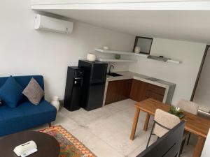 een woonkamer met een blauwe bank en een tafel bij SUNSET-LOFT Seminyak in Seminyak