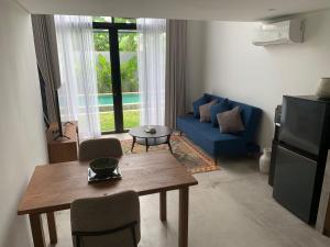een woonkamer met een tafel en een blauwe bank bij SUNSET-LOFT Seminyak in Seminyak