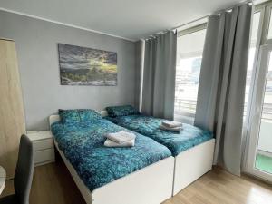 a bedroom with a bed with blue sheets and a window at Work & Stay in Neuss in Neuss