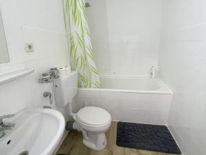 a bathroom with a toilet and a tub and a sink at Work & Stay in Neuss in Neuss +9 photos