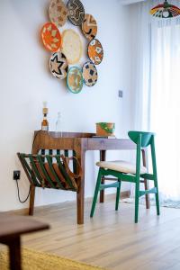 a table with a chair and plates on the wall at Westlands Nairobi, Marina Bay, 1 Bedroom Apartment, Swimming Pool, Gym, Workspace, JW Homes in Nairobi +27 photos