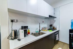 a kitchen with white cabinets and a sink at Westlands Nairobi, Marina Bay, 1 Bedroom Apartment, Swimming Pool, Gym, Workspace, JW Homes in Nairobi