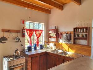 a kitchen with a sink and a stove and a window at Vellies Getaway in Buffelspoort
