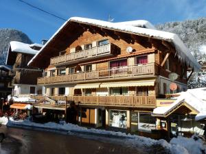 a large wooden building with snow on it at Appart 4★, 7 pers, La Clusaz centre, 3 ch, proche pistes - FR-1-304-206 in La Clusaz