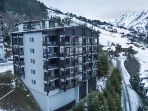 an apartment building in the mountains with snow on the ground at Appartement 4★, 8 pers, sauna, 3 ch, balcon sud, vue La Clusaz - FR-1-304-217 in La Clusaz