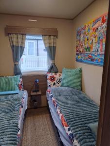 a bedroom with two twin beds and a window at Seton Sands Holiday Village GULLANE 5 in Longniddry +6 photos