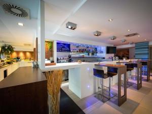 uma grande cozinha com um bar com bancos de bar em Ibis Styles Linz em Linz