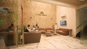 a man sitting at a desk in a lobby with a laptop at The Sky Imperial Sethji Ni Wadi in Indore +70 photos