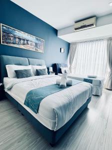a bedroom with a large bed with blue walls at Opulent Nights Sky Hotel 2BR Family Stay KK in Kota Kinabalu +29 photos
