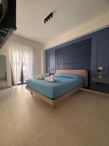 ein Schlafzimmer mit einem großen Bett mit blauen Wänden in der Unterkunft Amarcord in Laureana di Borrello