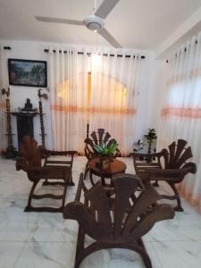un salon avec des chaises, des tables et un ventilateur de plafond dans l'établissement Vista bella, à Tangalle