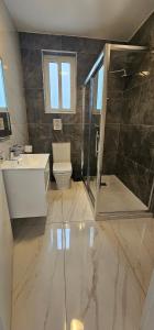ein Badezimmer mit Toilette, Waschbecken und Dusche in der Unterkunft Stylish Two Bedroom Two Bathrooms Flat at The Promenade Tigne Jo1 in Il-Gżira taʼ Forti Manoel