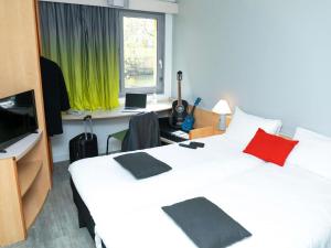 a hotel room with two beds and a desk with a computer at ibis Metz Centre Cathedrale in Metz