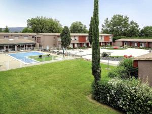 a large yard with a pool and a building at ibis Montélimar Nord in Saulce-sur-Rhône