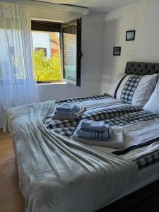 a large bed in a room with a window at Guest House Lona in Golubac