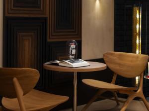 ein Tisch mit einem Buch und zwei Stühlen in der Unterkunft Hotel Maison Louise Lille Centre - Handwritten Collection in Lille