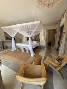 une chambre avec un lit à baldaquin dans l'établissement Maya kobe Beachfront Retreat Kilifi, à Kilifi