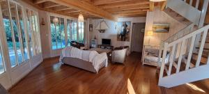 een woonkamer met een bank en een trap bij Belle Villa Familiale entre Agapanthes et Bambous in Lège-Cap-Ferret