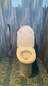 a bathroom with a toilet with a shower at Sauraha Tharu Village in Sauraha