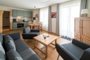 ein Wohnzimmer mit Sofa, Stühlen und einem Tisch in der Unterkunft Haus Sonnenschein Göhren in Göhren